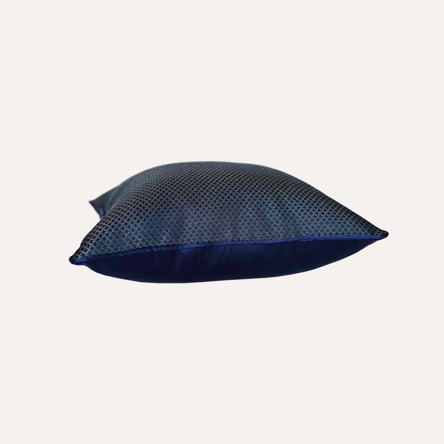 The navy blue cushion cover features subtle gold mesh designs.