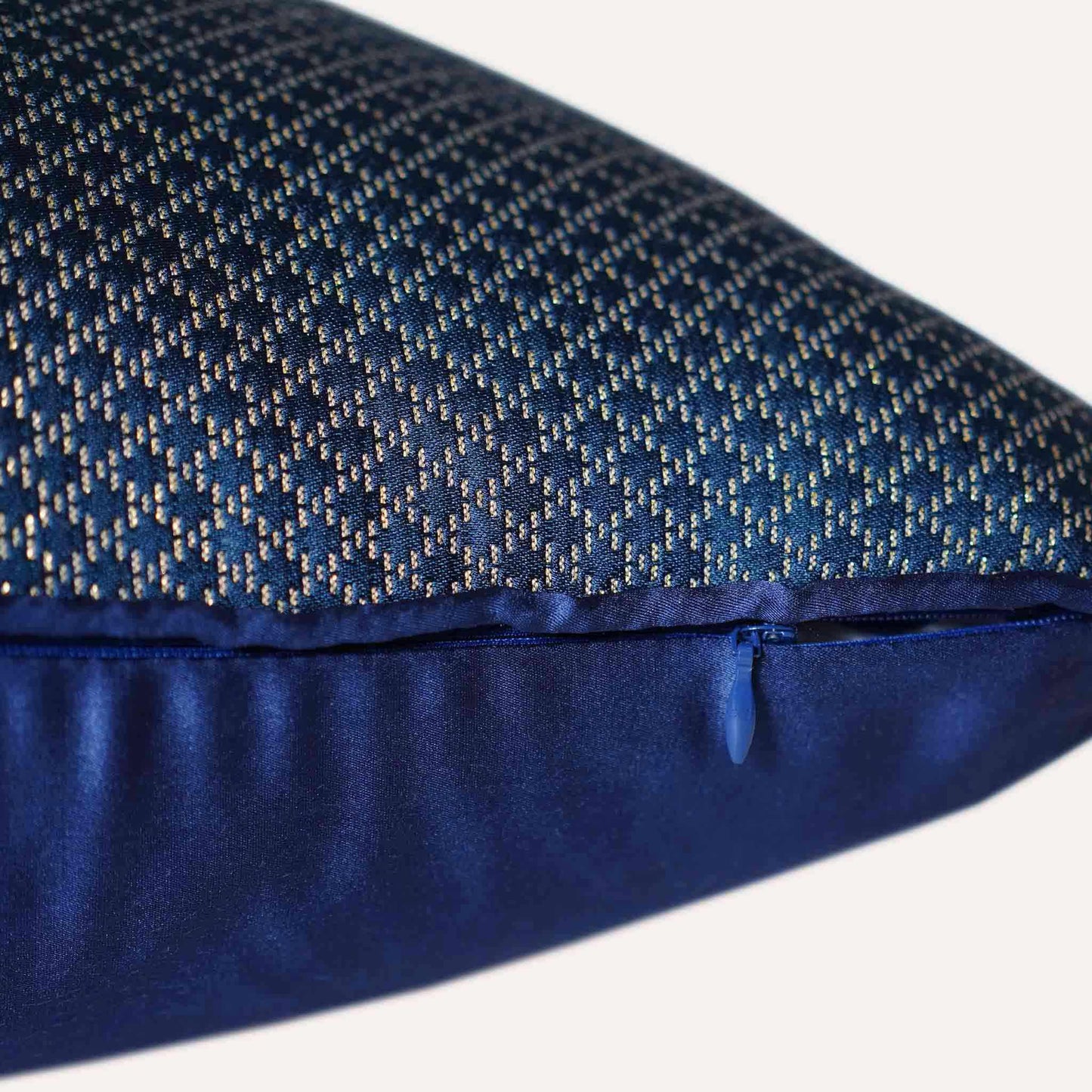 The navy blue cushion cover features subtle gold mesh designs with invisible zipper.