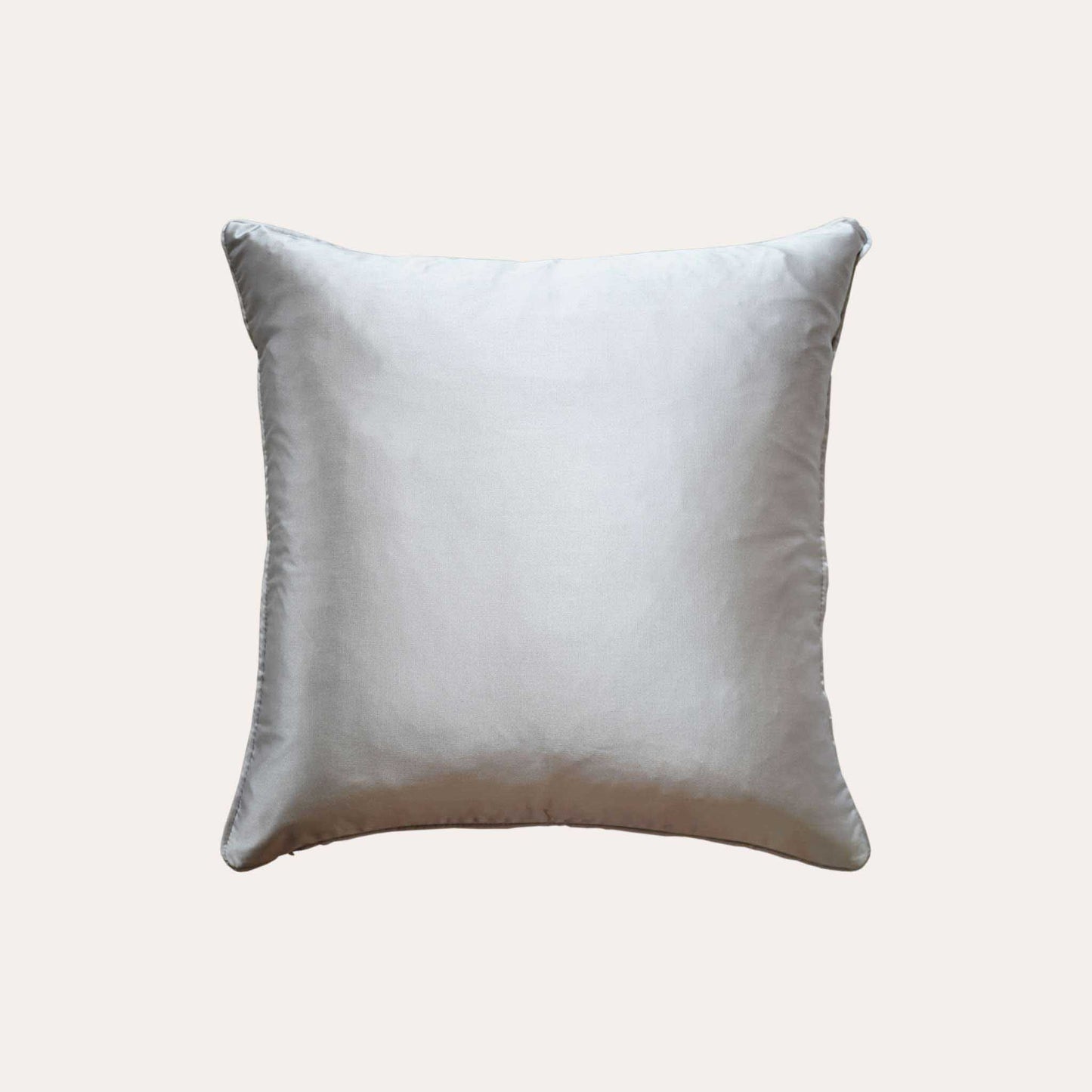A chic silver cushion cover adorned with intricate off-white jacquard floral designs with sliver back.