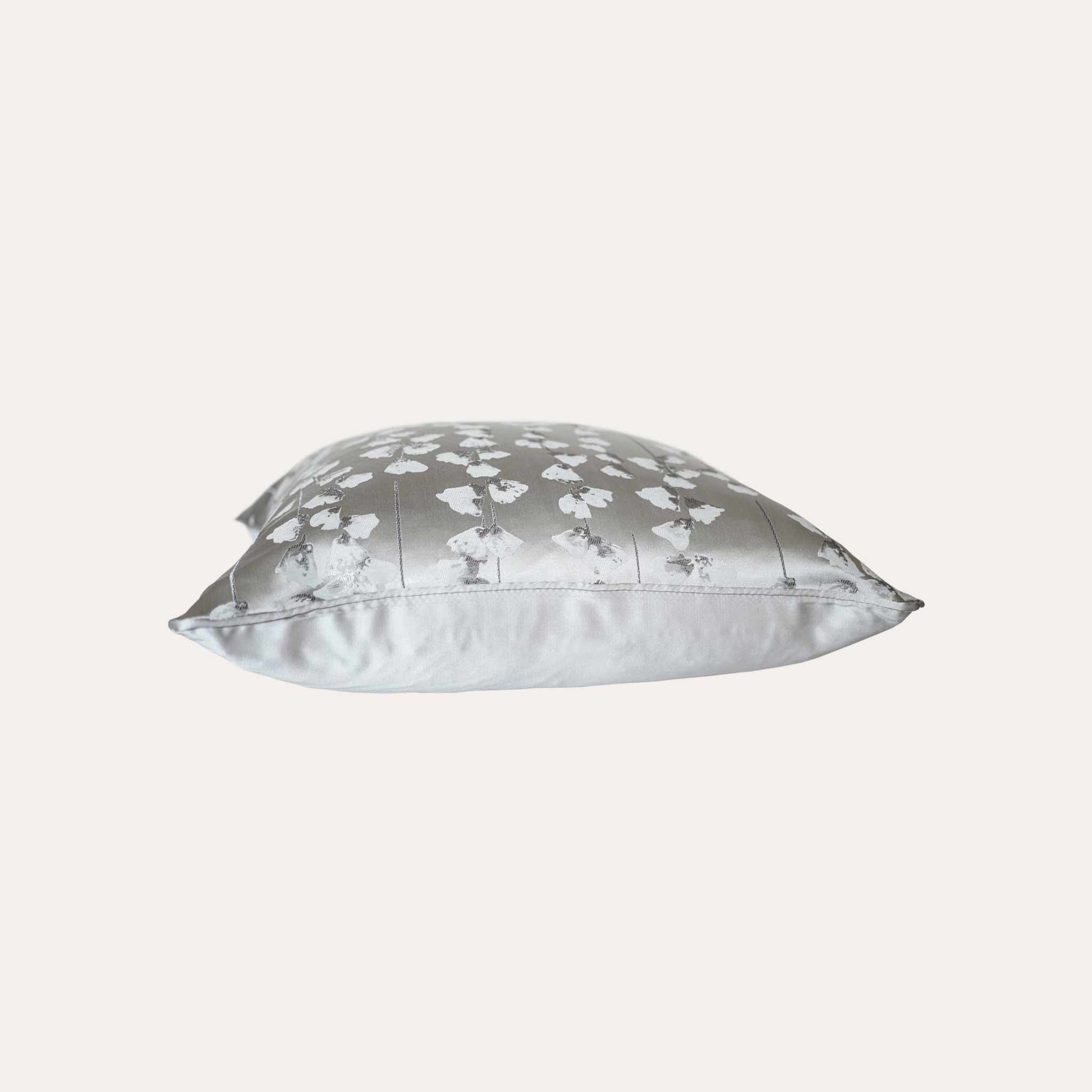 A chic silver cushion cover adorned with intricate off-white jacquard floral designs.
