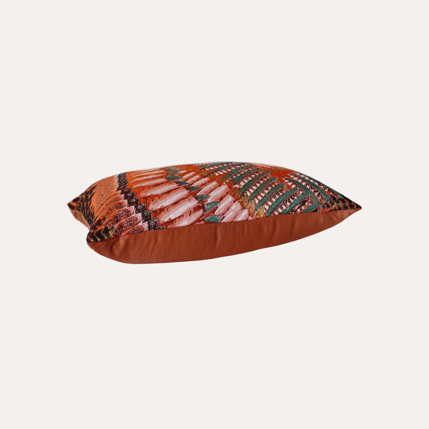 A pattern resembling orange, green, and white feathers on the lumbar cushion cover.