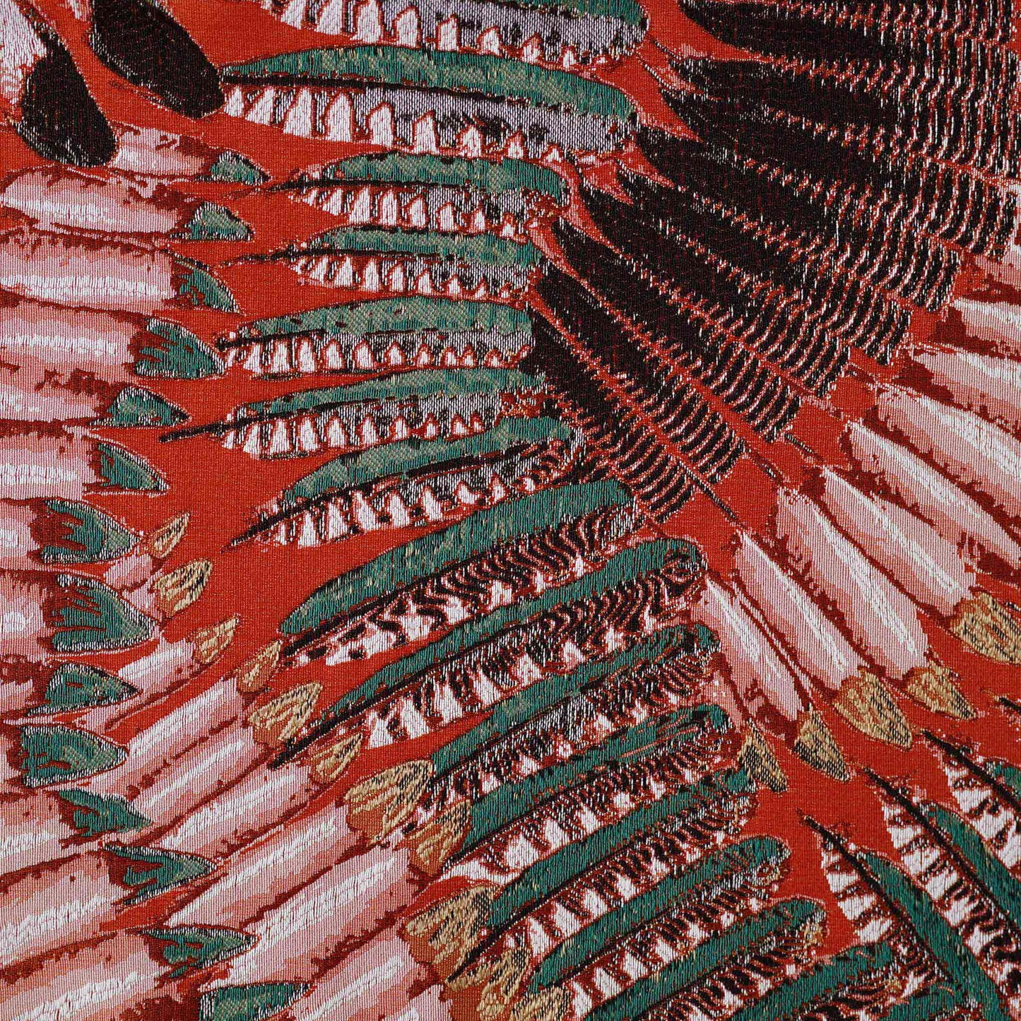 A pattern resembling orange, green, and white feathers on the lumbar cushion cover.
