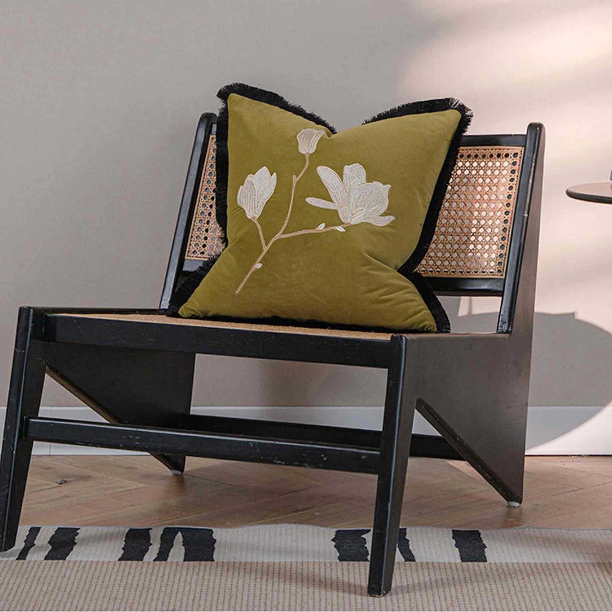 Oriental floral embroidery, black burlap with yellow-green velvet cushion on chair.