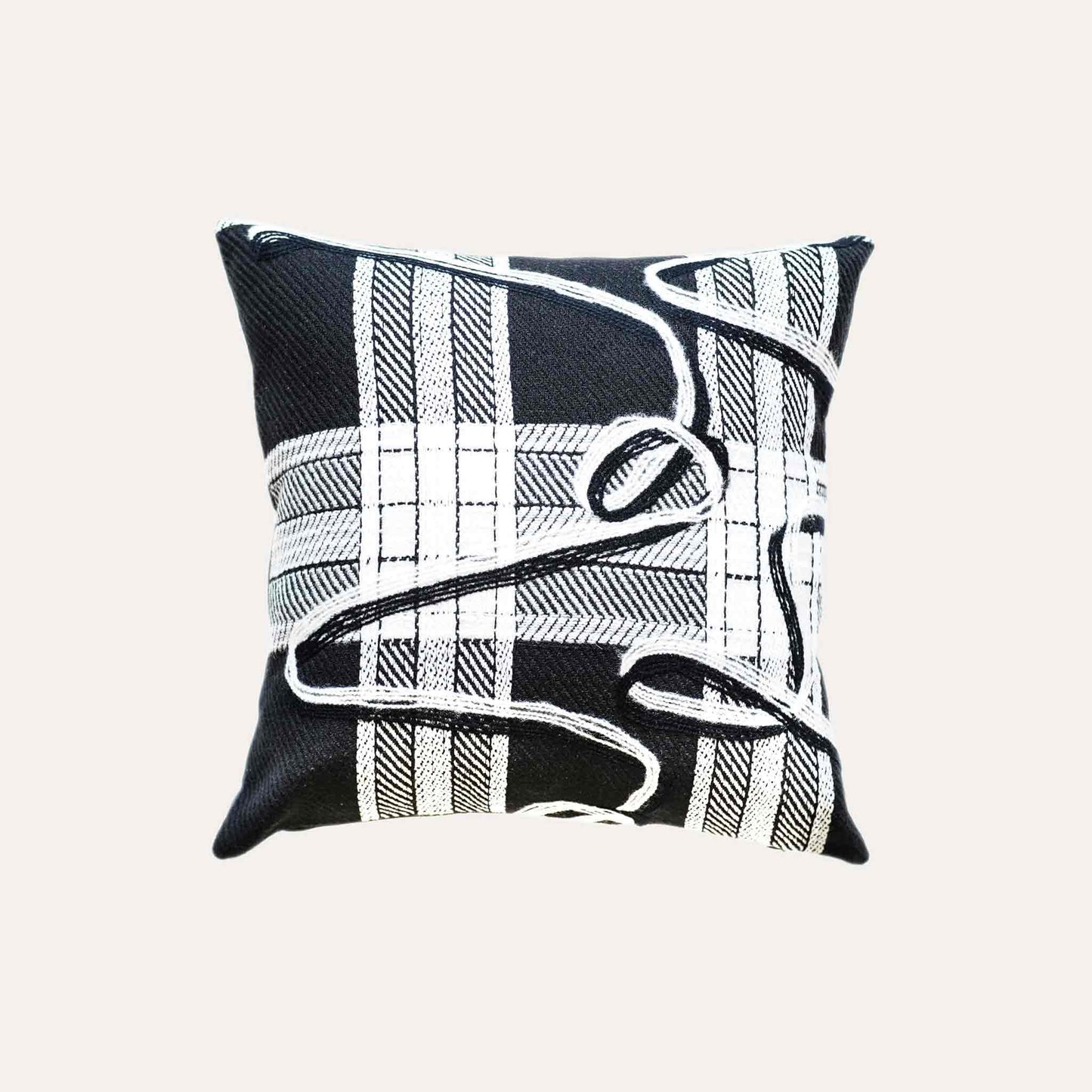 A black and white plaid and ribbon cushion cover.