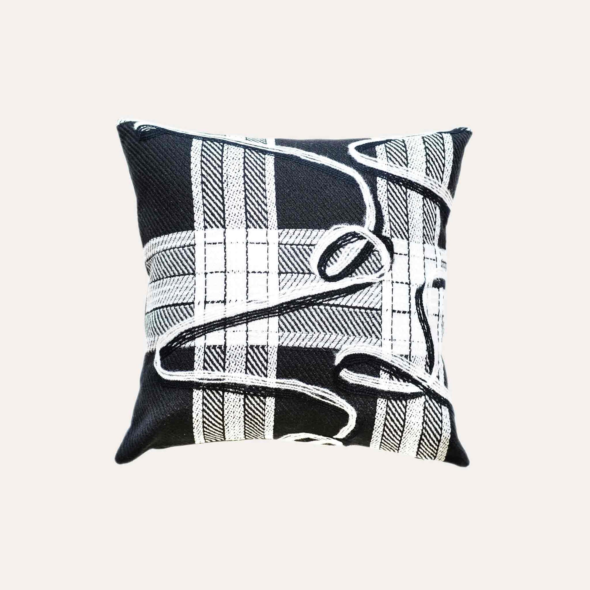 A black and white plaid and ribbon cushion cover.