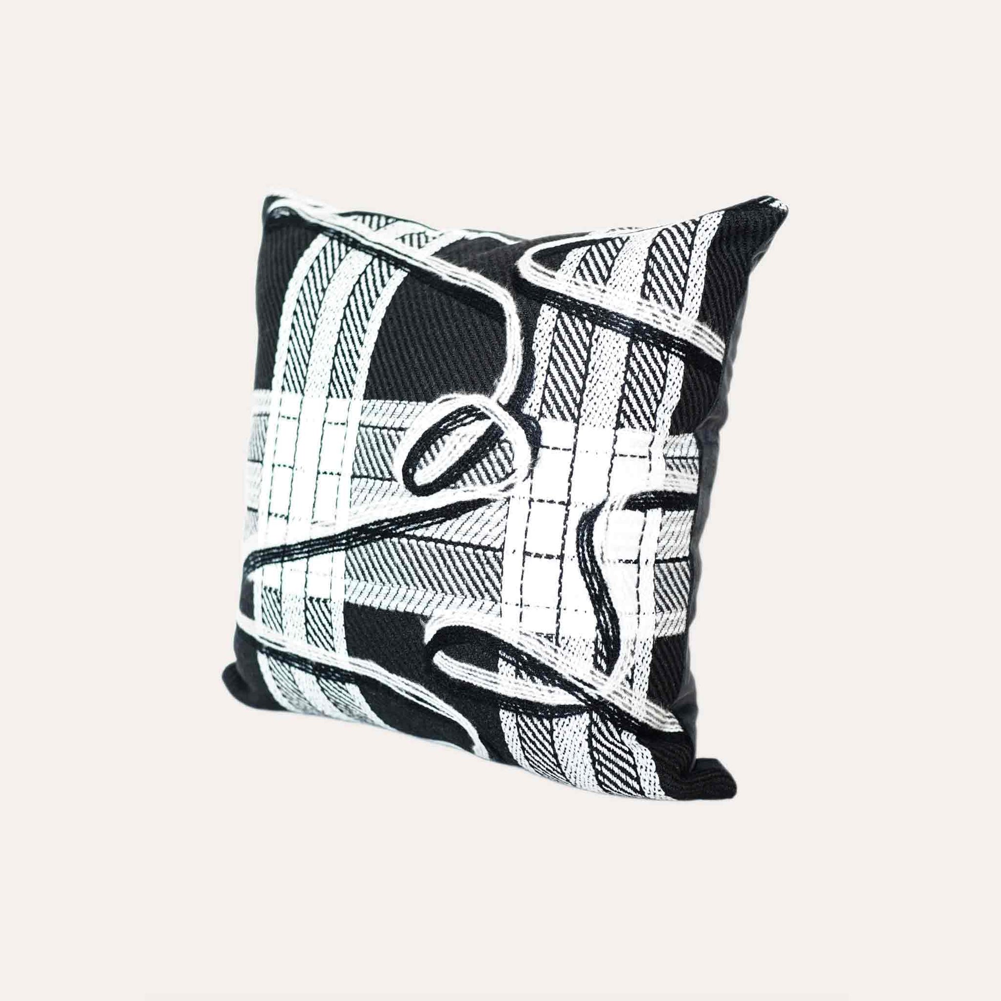 A black and white plaid and ribbon cushion cover.