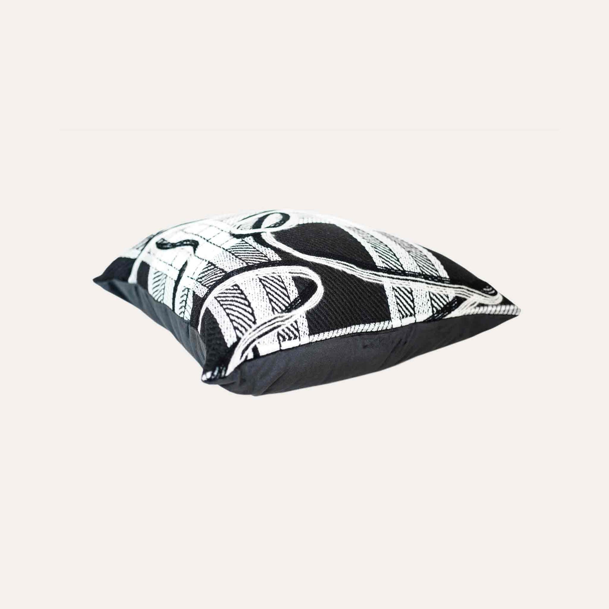 A black and white plaid and ribbon cushion cover.