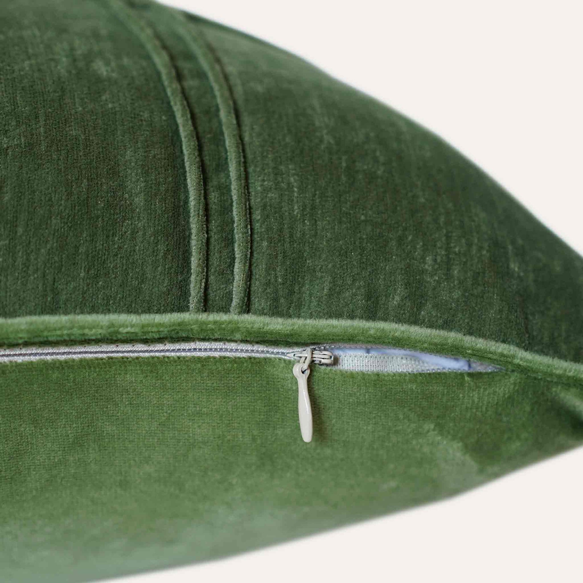 Rectangular cushion cover in sage green velvet with invisible zipper.