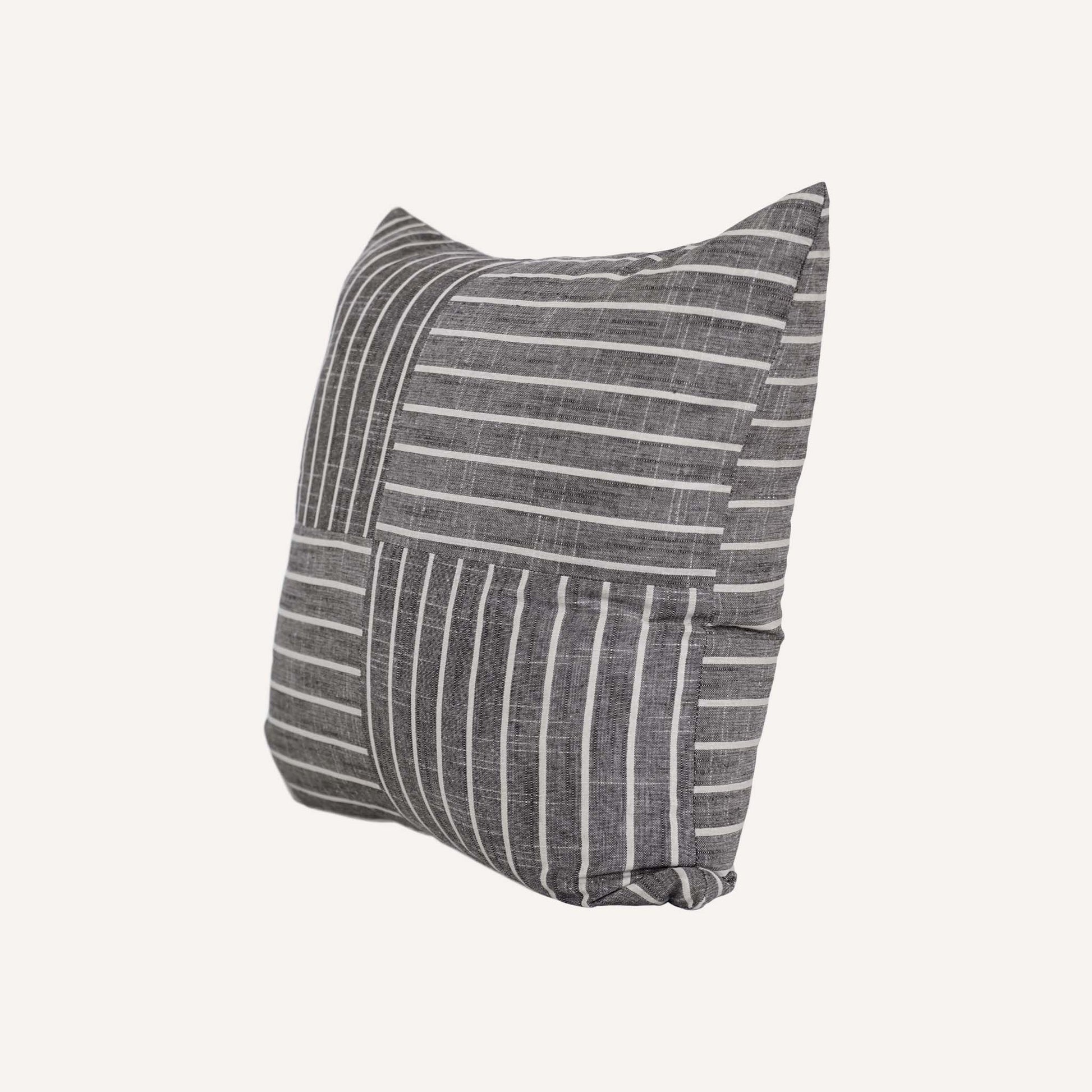 White striped pattern cushion on grey background.