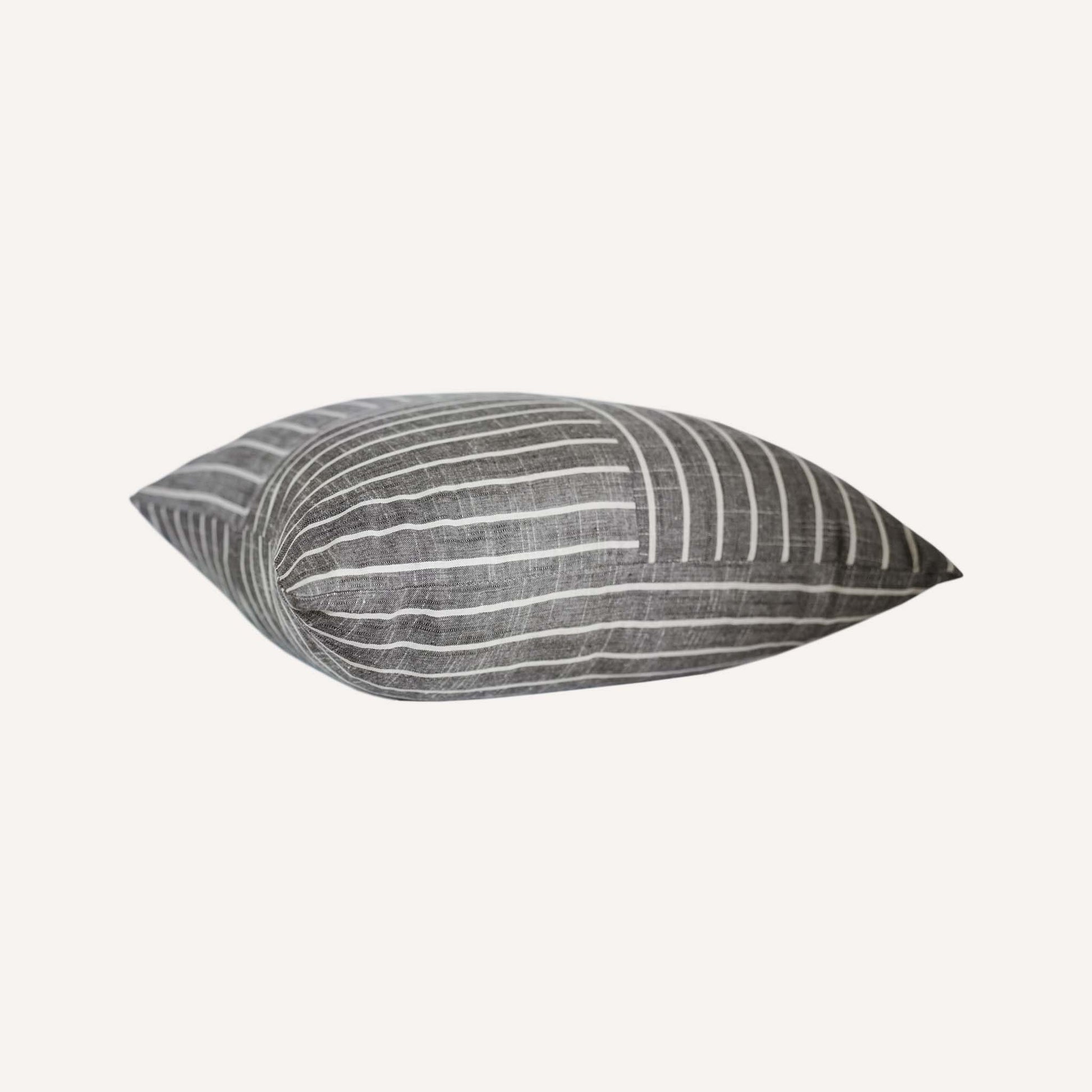 White striped pattern cushion on grey background.