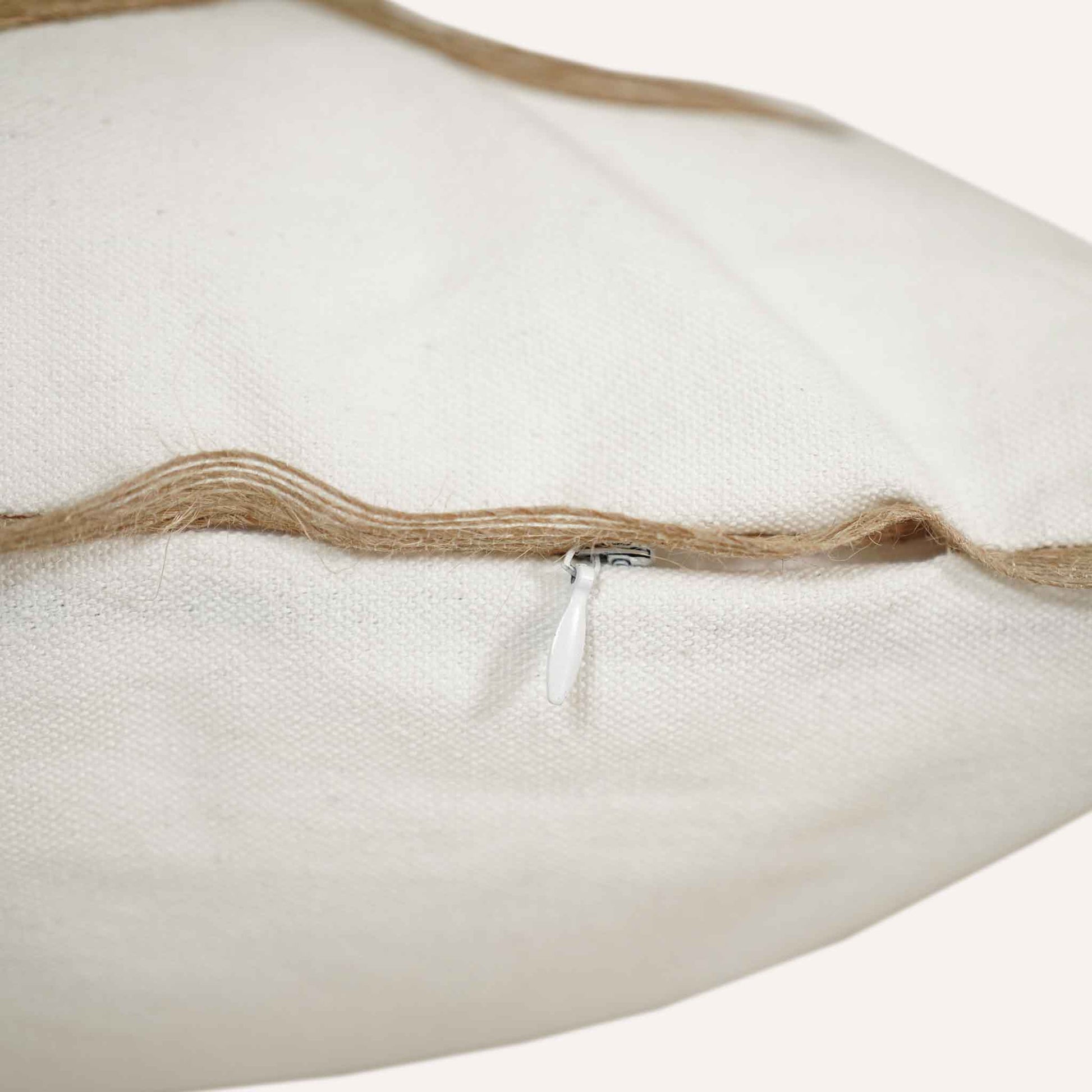 Close-up of the invisible zip on the white background linen cushion.