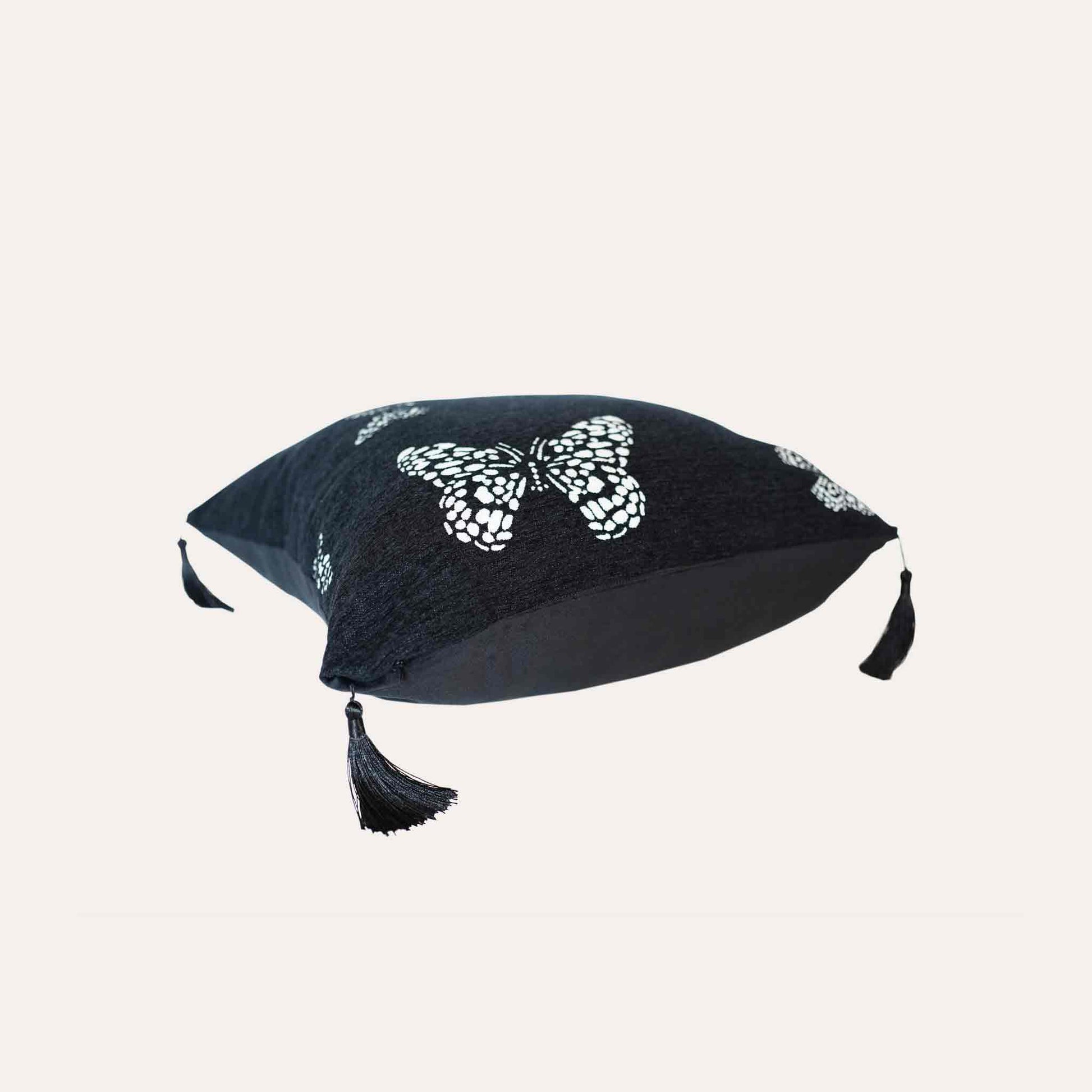 White butterfly on black background, fringed chenille cushion cover.