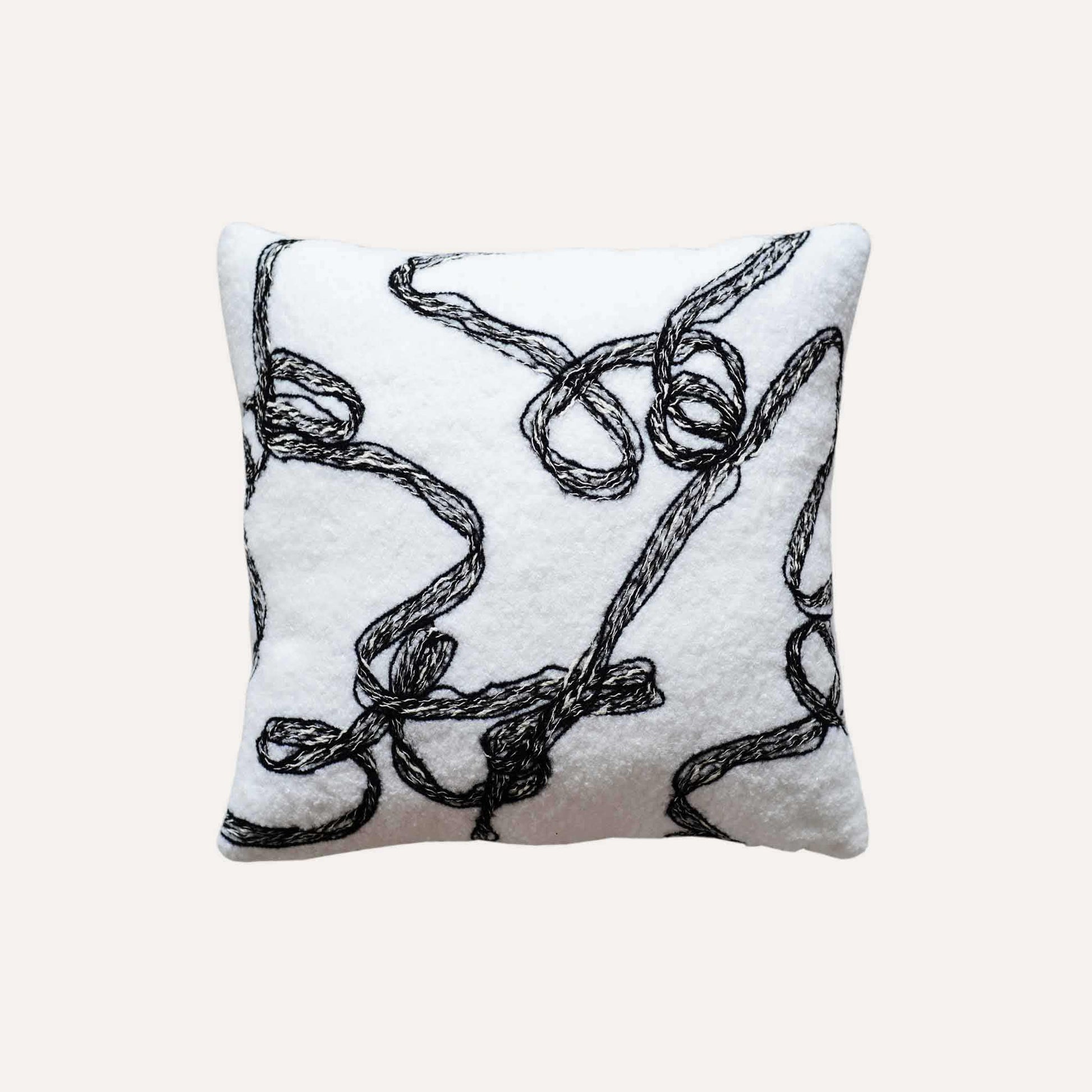 Modern wool cushion cover with black and white ribbon patterns.