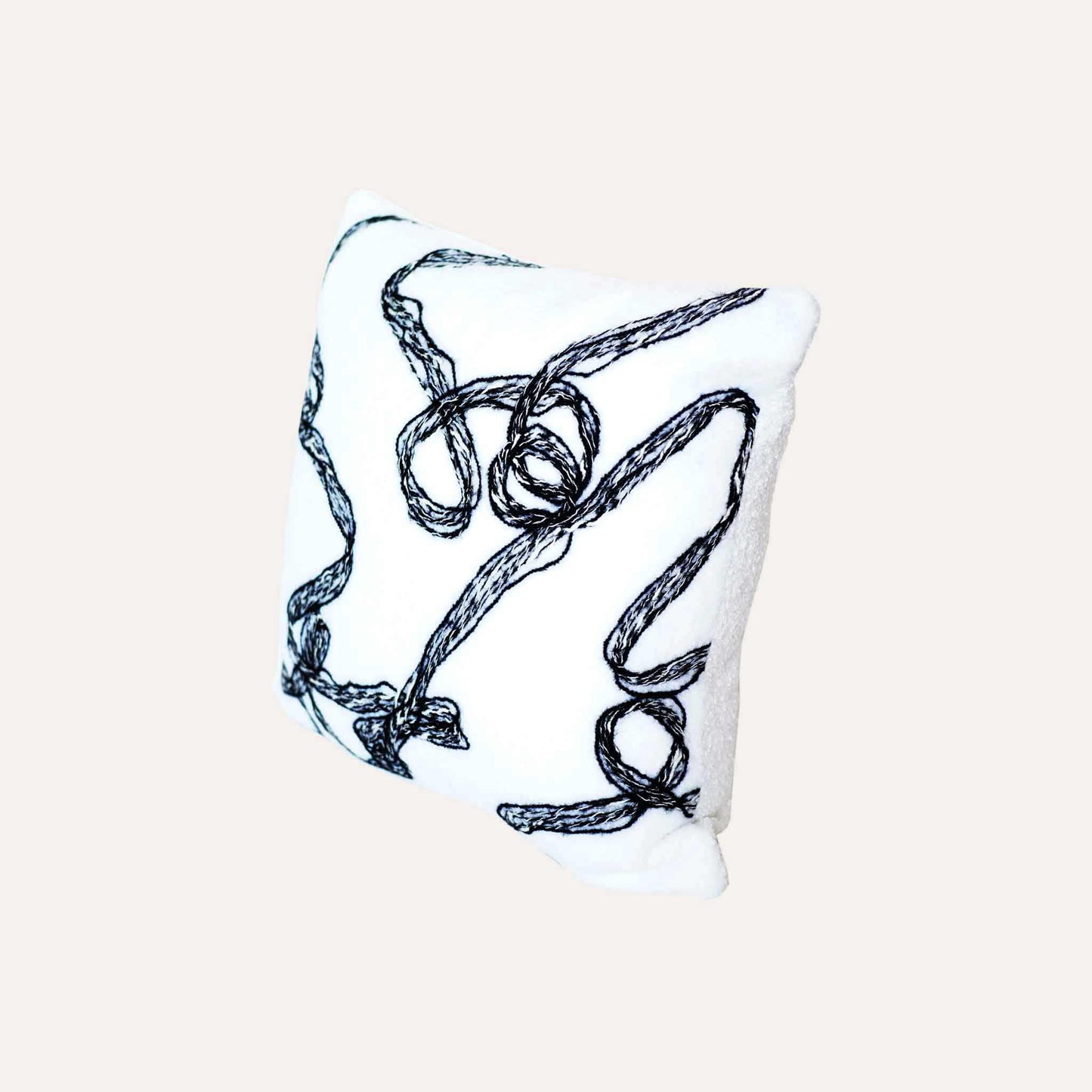 Modern wool cushion cover with black and white ribbon patterns.