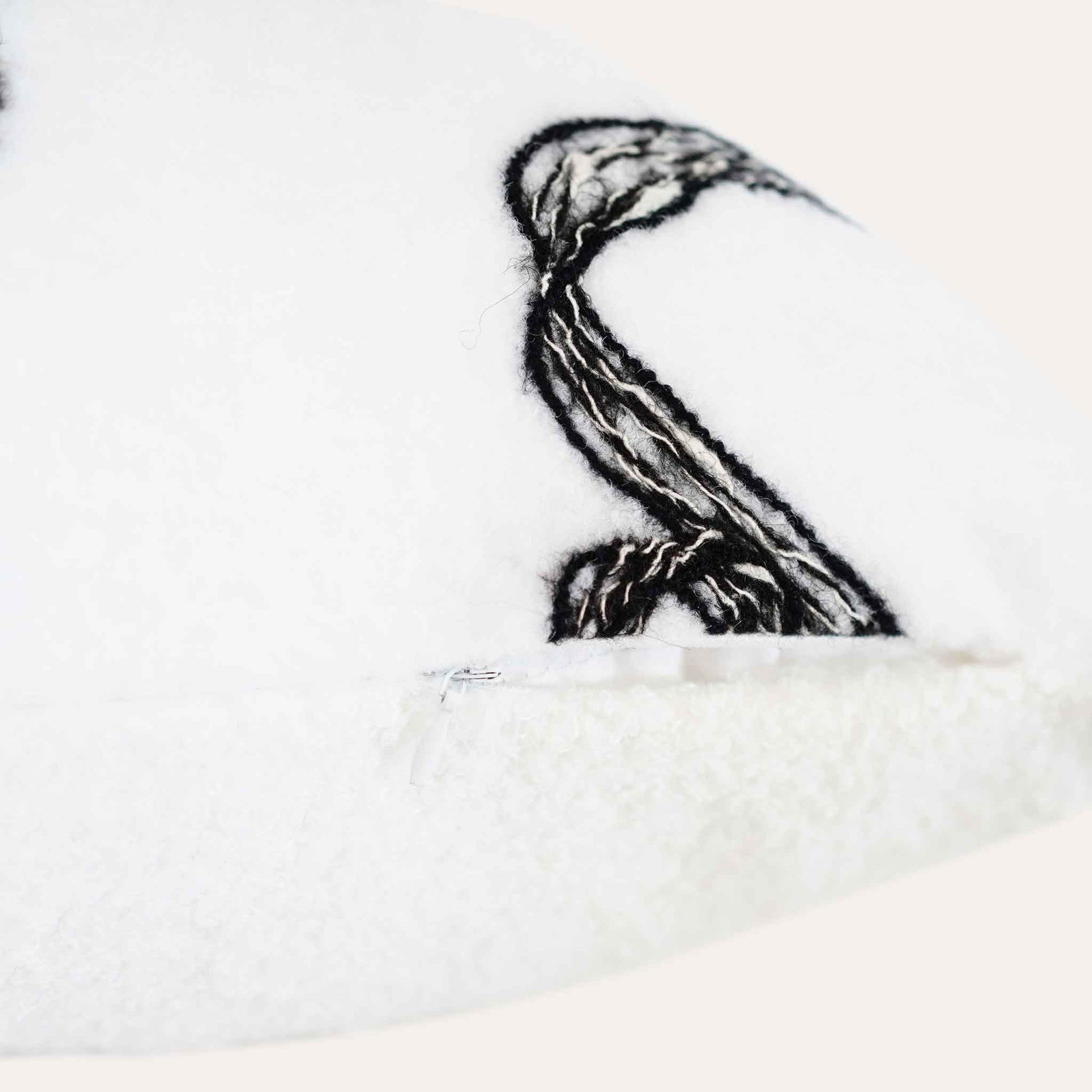 Modern wool cushion in black and white ribbon pattern with invisible zipper.