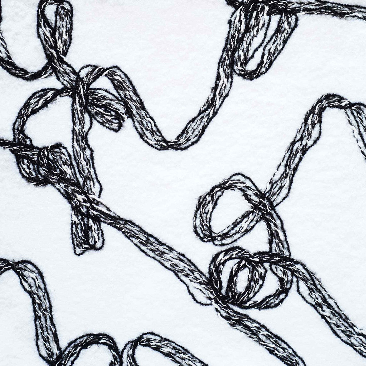 Modern wool cushion cover with black and white ribbon patterns.