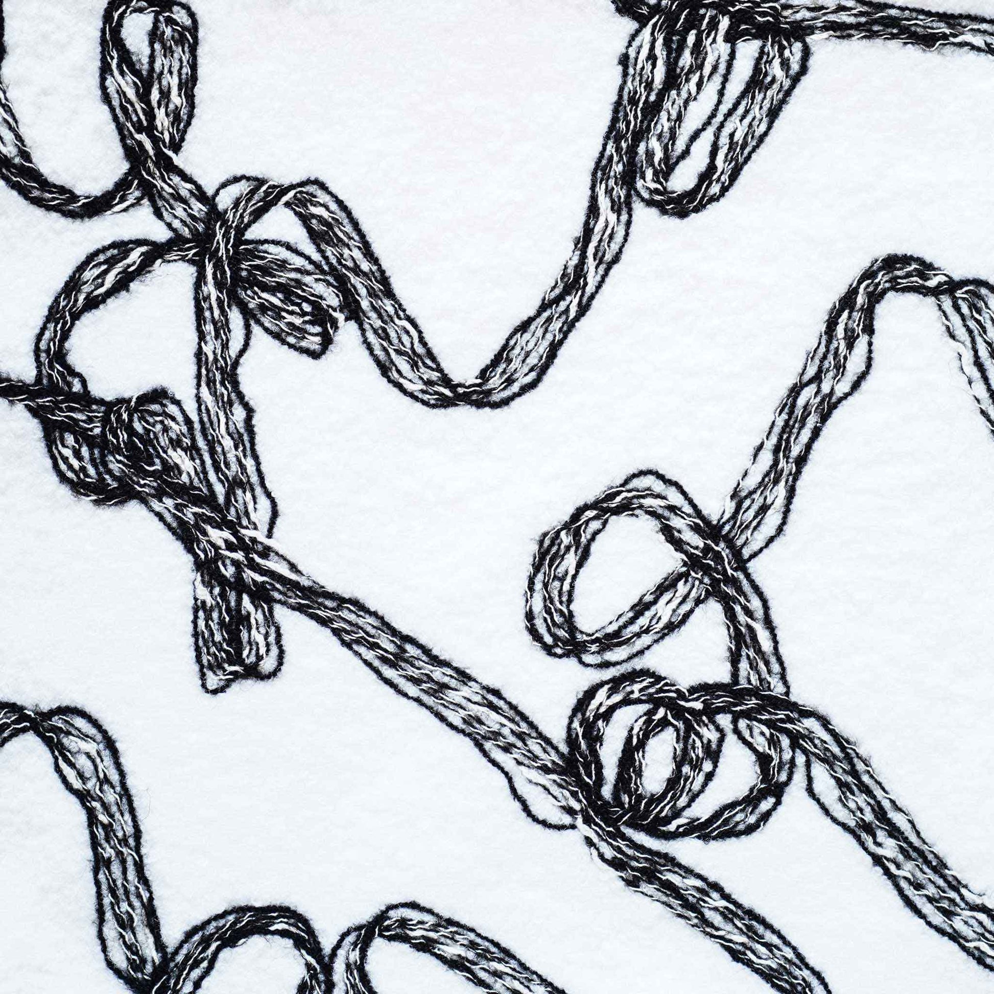 Modern wool cushion cover with black and white ribbon patterns.