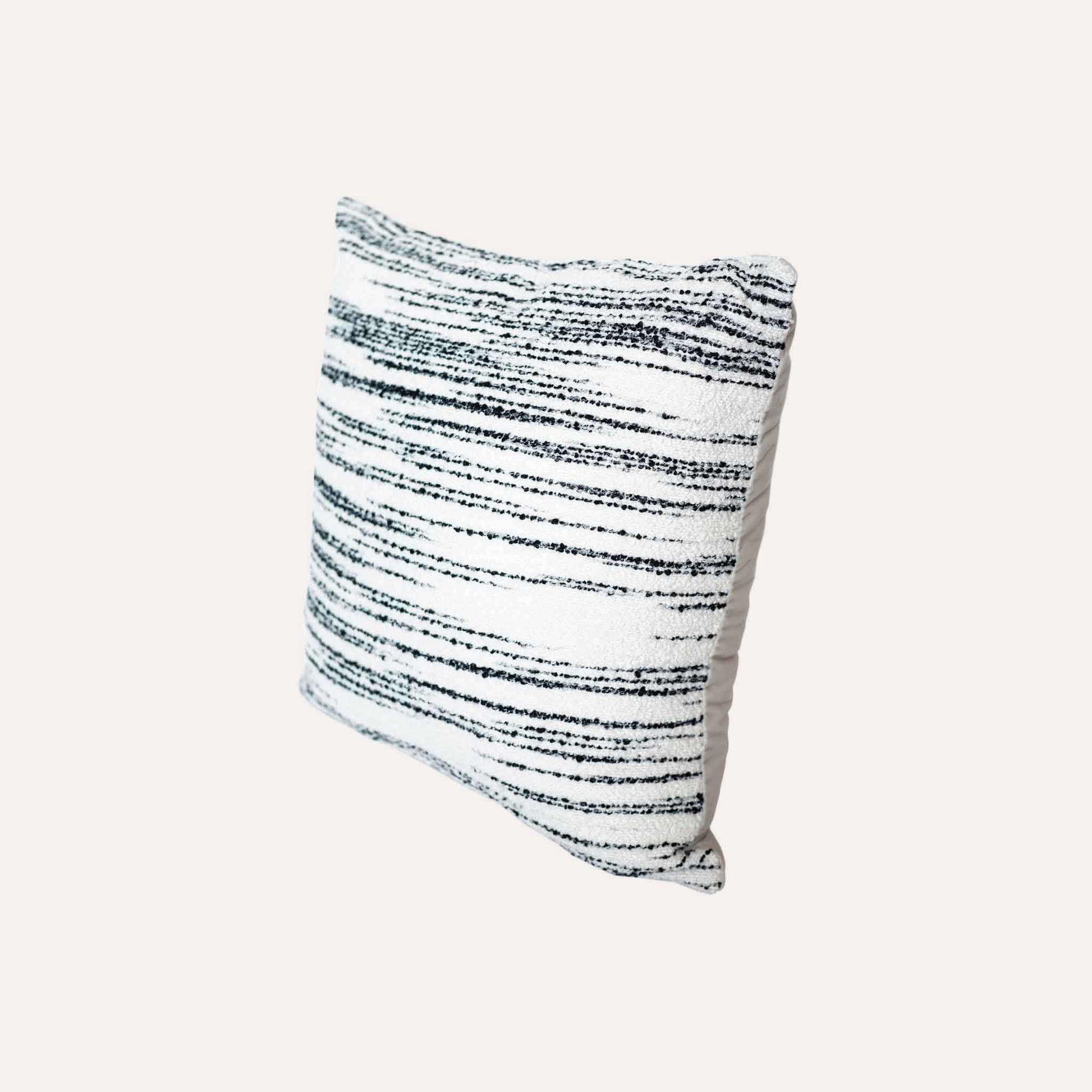 White wool cushion with black crayon strokes.