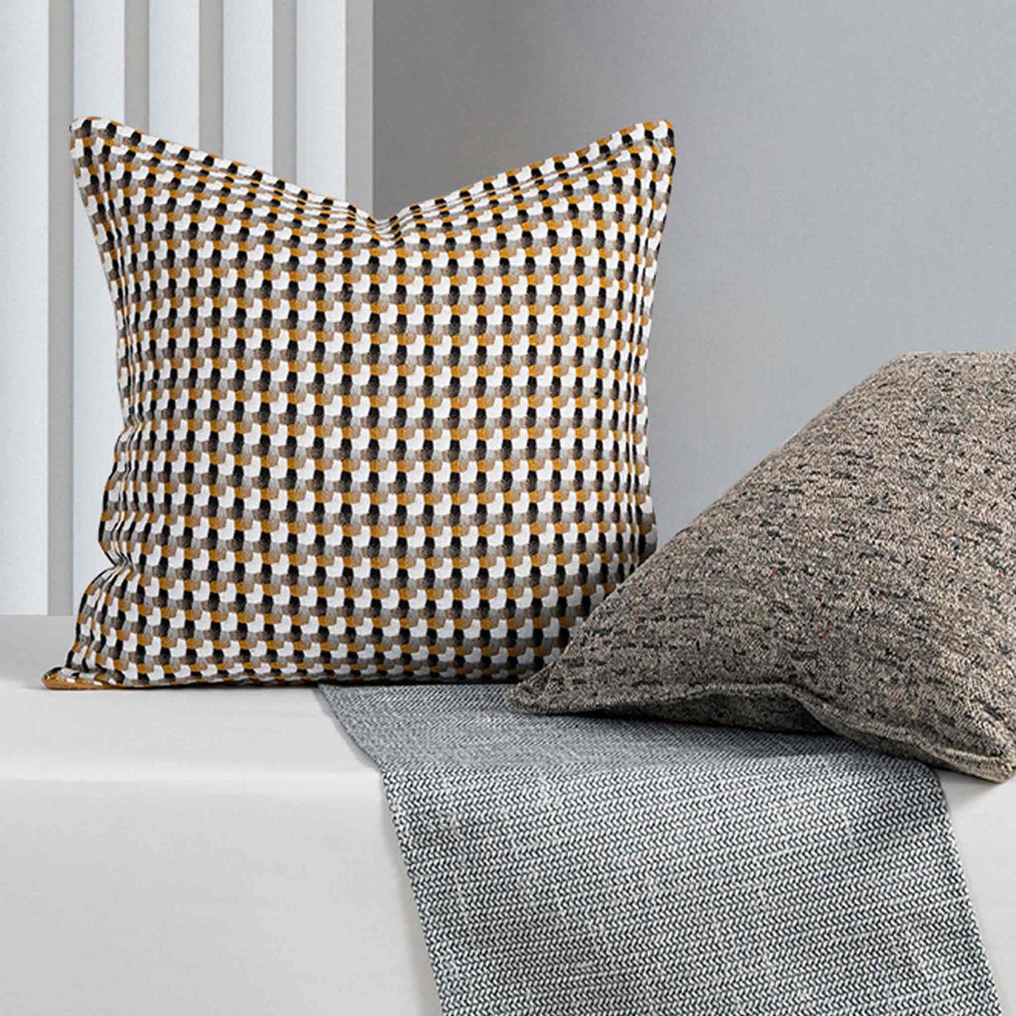A beautiful yellow and black woven textured cushion with a gray cushion.