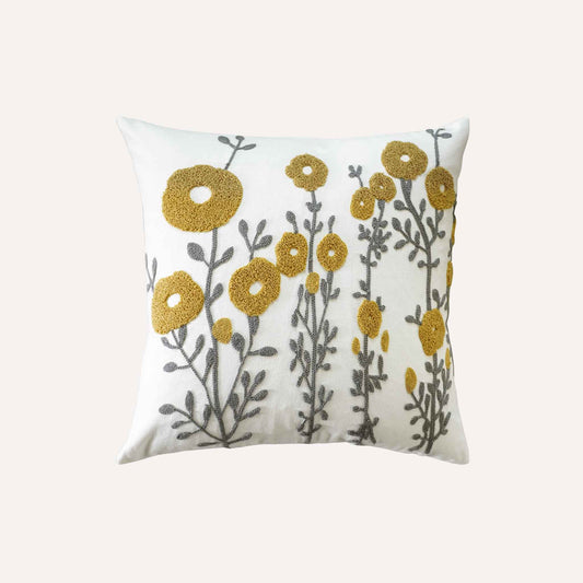 Tufted yellow flower cushion on white background.