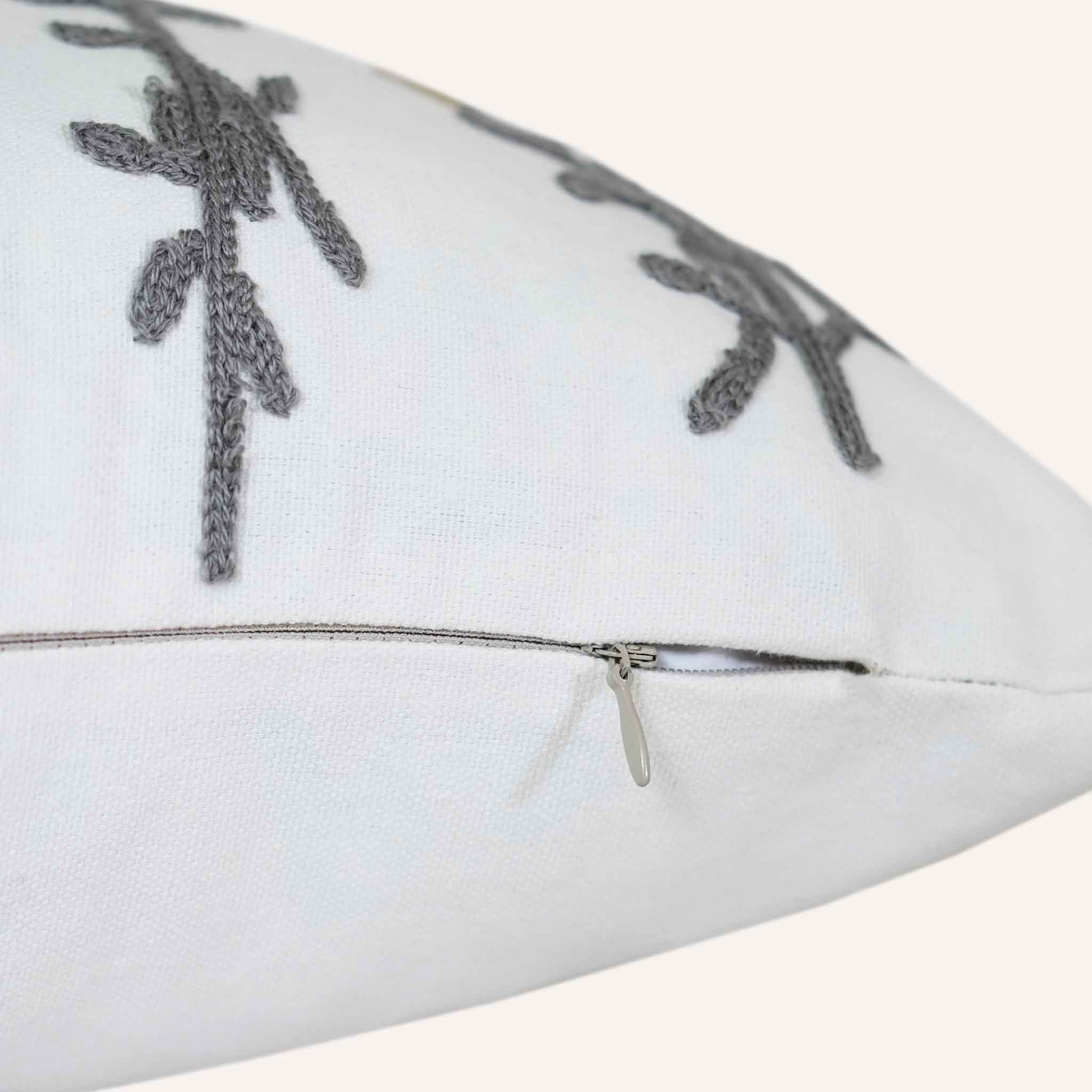 Invisible zip close-up of tufted yellow flower cushion on white background.