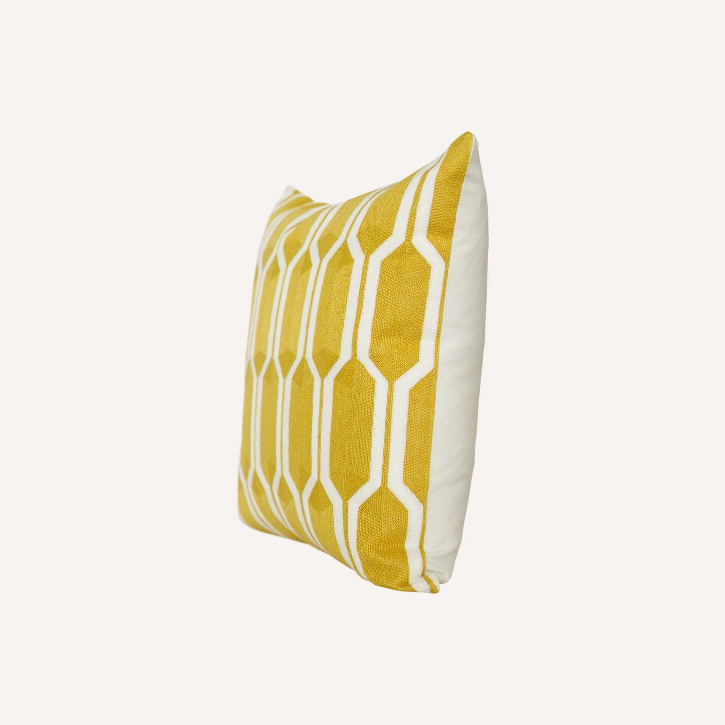 A yellow and white geometric cushion with a modern design using bold shapes and lines.