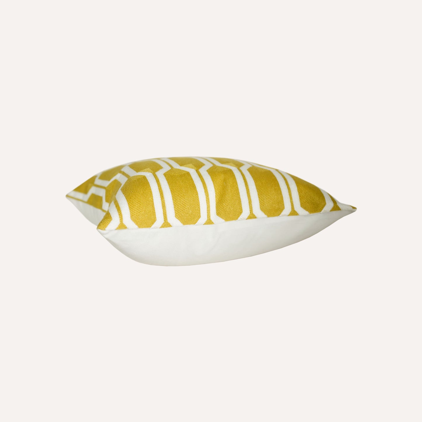 A yellow and white geometric cushion with a modern design using bold shapes and lines.